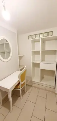 a white dressing room with a bench and a mirror at Appartement 3 pièces sur Nice Centre in Nice