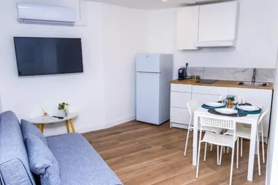 a living room with a couch and a table and a kitchen at NIce proche mer in Nice