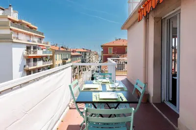 a balcony with tables and chairs on a building at Happyfew Fodere in Nice