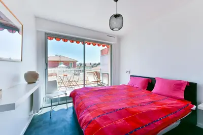 a bedroom with a red bed and a balcony at Happyfew Fodere in Nice