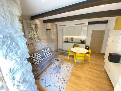 a living room with a table and chairs and a kitchen at COCON AP4446 By Riviera Holiday Homes in Villefranche-sur-Mer