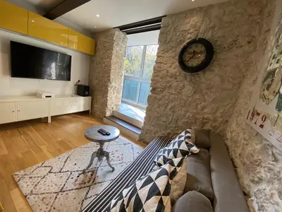 a living room with a couch and a clock on a wall at COCON AP4446 By Riviera Holiday Homes in Villefranche-sur-Mer