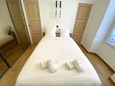 a large white bed with two pillows on it at COCON AP4446 By Riviera Holiday Homes in Villefranche-sur-Mer