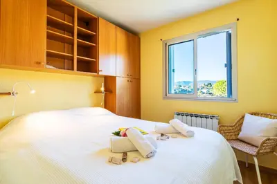 a bedroom with a large white bed with a window at LE JARDIN BLEU AP4388 By Riviera Holiday Homes in Nice