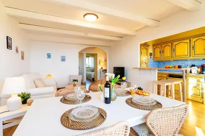 a kitchen and living room with a table and chairs at LE JARDIN BLEU AP4388 By Riviera Holiday Homes in Nice