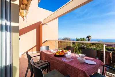 a table with a bowl of fruit on a balcony at LE JARDIN BLEU AP4388 By Riviera Holiday Homes in Nice
