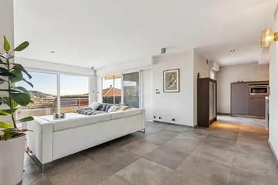 a living room with a couch and a large window at Bay of Angels by ecoflats in Nice