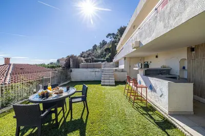 a patio with a table and chairs on the grass at Bay of Angels by ecoflats in Nice