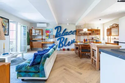 a living room with a blue couch and a kitchen at 2 chambres, balcons, vue imprenable, climatisation - PALACE BLEU in Nice