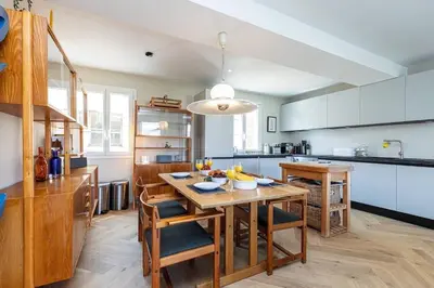 a kitchen with a wooden table with chairs and a dining room at 2 chambres, balcons, vue imprenable, climatisation - PALACE BLEU in Nice