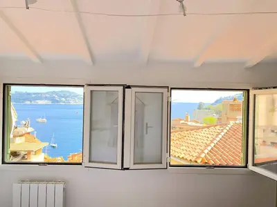a room with three windows with a view of the ocean at PEARL AP4444 By Riviera Holiday Homes in Villefranche-sur-Mer