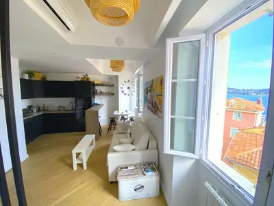 a living room with a white couch and a large window at PEARL AP4444 By Riviera Holiday Homes in Villefranche-sur-Mer