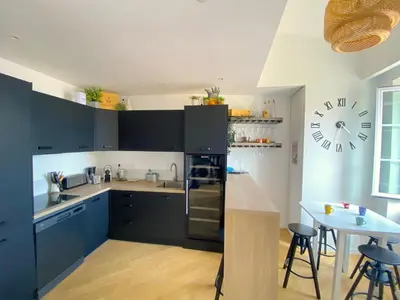 a kitchen with blue cabinets and a clock on the wall at PEARL AP4444 By Riviera Holiday Homes in Villefranche-sur-Mer