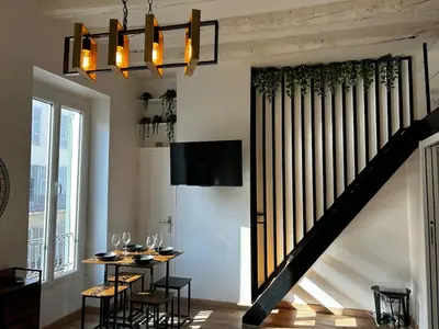 a dining room with a table and a staircase at Cosy Studio Climatisé en plein cœur de Nice in Nice