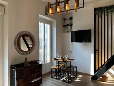 a dining room with a table and a mirror at Cosy Studio Climatisé en plein cœur de Nice in Nice