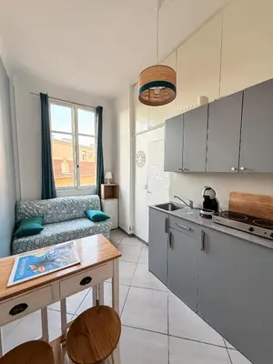 a kitchen with a couch and a table in a room at PORT - Charmant Studio in Nice