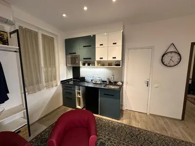 a kitchen with a counter and a clock on the wall at Promenade des Anglais With AC Near Negresco in Nice