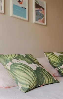 a bed with a pillow on it with pictures on the wall at Appartement cosy Cagnes-sur-Mer in Cagnes-sur-Mer