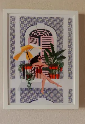 a picture of a woman sitting in a chair with an umbrella at Appartement cosy Cagnes-sur-Mer in Cagnes-sur-Mer