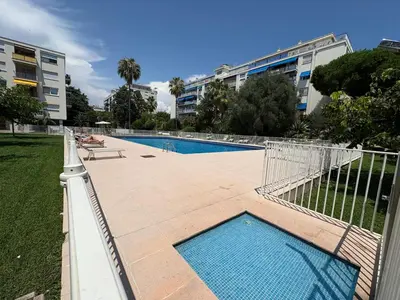 a swimming pool with a fence next to a building at NICE La Palmeraie Pool BEACH AC in Nice