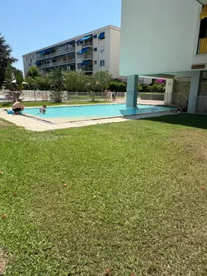 a swimming pool in a building with a grass yard at NICE La Palmeraie Pool BEACH AC in Nice