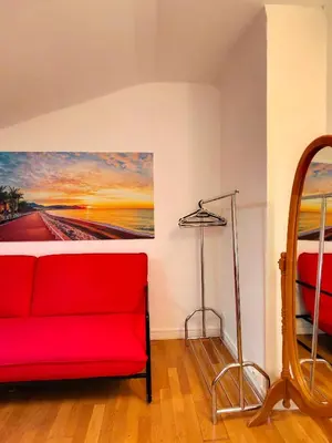 a red couch in a room with a painting on the wall at Jolie chambre Privée Centre-Ville in Nice