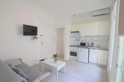 a white living room with a couch and a table at Happyfew Le Miramar in Nice