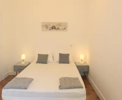 a bedroom with a large white bed with two night stands at Happyfew Le Miramar in Nice
