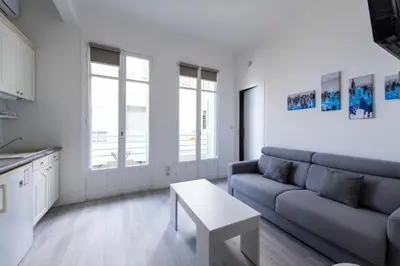 a living room with a couch and a table at Happyfew Le Miramar in Nice