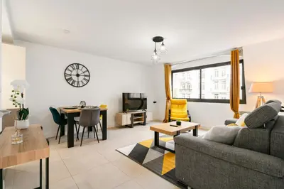 a living room with a couch and a table at Suite Matisse FSHH - Generale in Nice