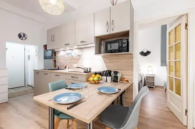 a kitchen and dining room with a wooden table and chairs at FEEL HOME - Poissonnerie in Nice