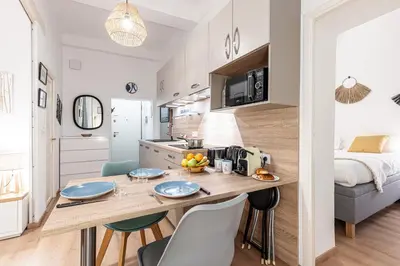 a kitchen and living room with a table and chairs at FEEL HOME - Poissonnerie in Nice