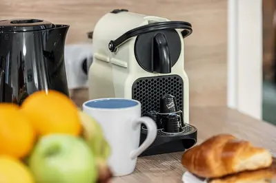 a coffee maker sitting on a table next to some fruit at FEEL HOME - Poissonnerie in Nice