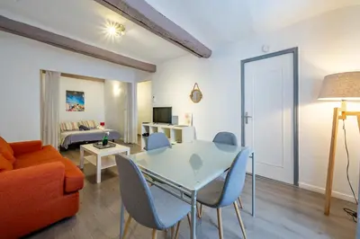 a living room with a table and chairs and a couch at Vieux-Nice 2P climatisé Balcon in Nice