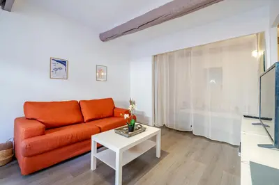 a living room with an orange couch and a table at Vieux-Nice 2P climatisé Balcon in Nice