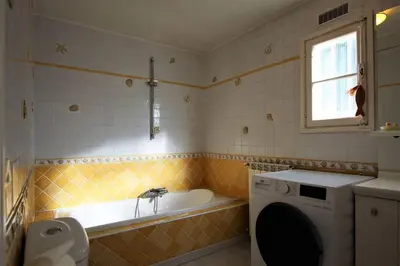 a bathroom with a tub and a washing machine at Sur les hauteurs de Nice, belle villa idéale en famille ou entre amis in Colomars