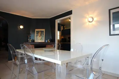 a dining room with a white table and chairs at Sur les hauteurs de Nice, belle villa idéale en famille ou entre amis in Colomars