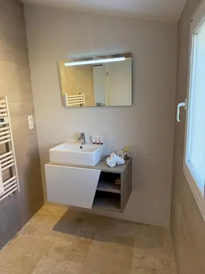 a bathroom with a white sink and a mirror at Maison avec jacuzzi privatif dans résidence in La Gaude