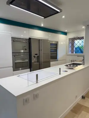 a large white kitchen with stainless steel appliances at Maison avec jacuzzi privatif dans résidence in La Gaude