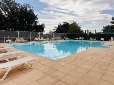 a large swimming pool with lounge chairs at Maison avec jacuzzi privatif dans résidence in La Gaude