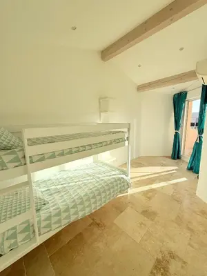 a bedroom with two bunk beds with blue curtains at Maison avec jacuzzi privatif dans résidence in La Gaude