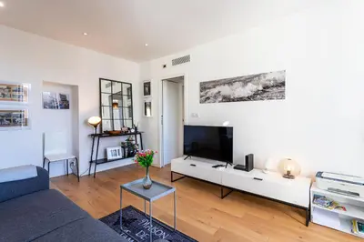 a living room with a couch and a tv at Garibaldi AP4447 By Riviera Holiday Homes in Nice