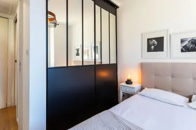 a bedroom with a black sliding closet door next to a bed at Garibaldi AP4447 By Riviera Holiday Homes in Nice