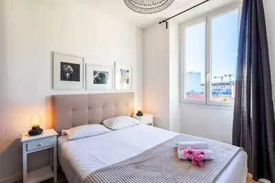 a bedroom with a white bed with flowers on it at Garibaldi AP4447 By Riviera Holiday Homes in Nice