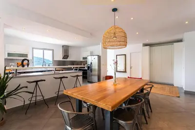 a kitchen and dining room with a wooden table and chairs at VILLA NIDAZUR VI4413 By Riviera Holiday Homes in Nice