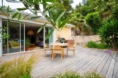 a wooden deck with a table and chairs on it at VILLA NIDAZUR VI4413 By Riviera Holiday Homes in Nice