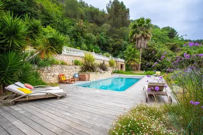 a backyard with a swimming pool and a wooden deck at VILLA NIDAZUR VI4413 By Riviera Holiday Homes in Nice