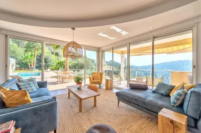 a living room with blue couches and a table at VILLA NIDAZUR VI4413 By Riviera Holiday Homes in Nice