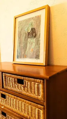 a painting sitting on top of a wooden dresser at Il Sole e Mare in Nice