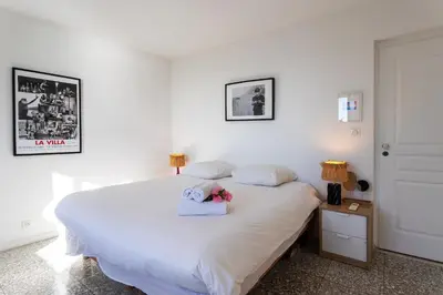 a bedroom with a white bed with a teddy bear on it at CASA ROSALIE VI4442 By Riviera Holiday Homes in Villefranche-sur-Mer